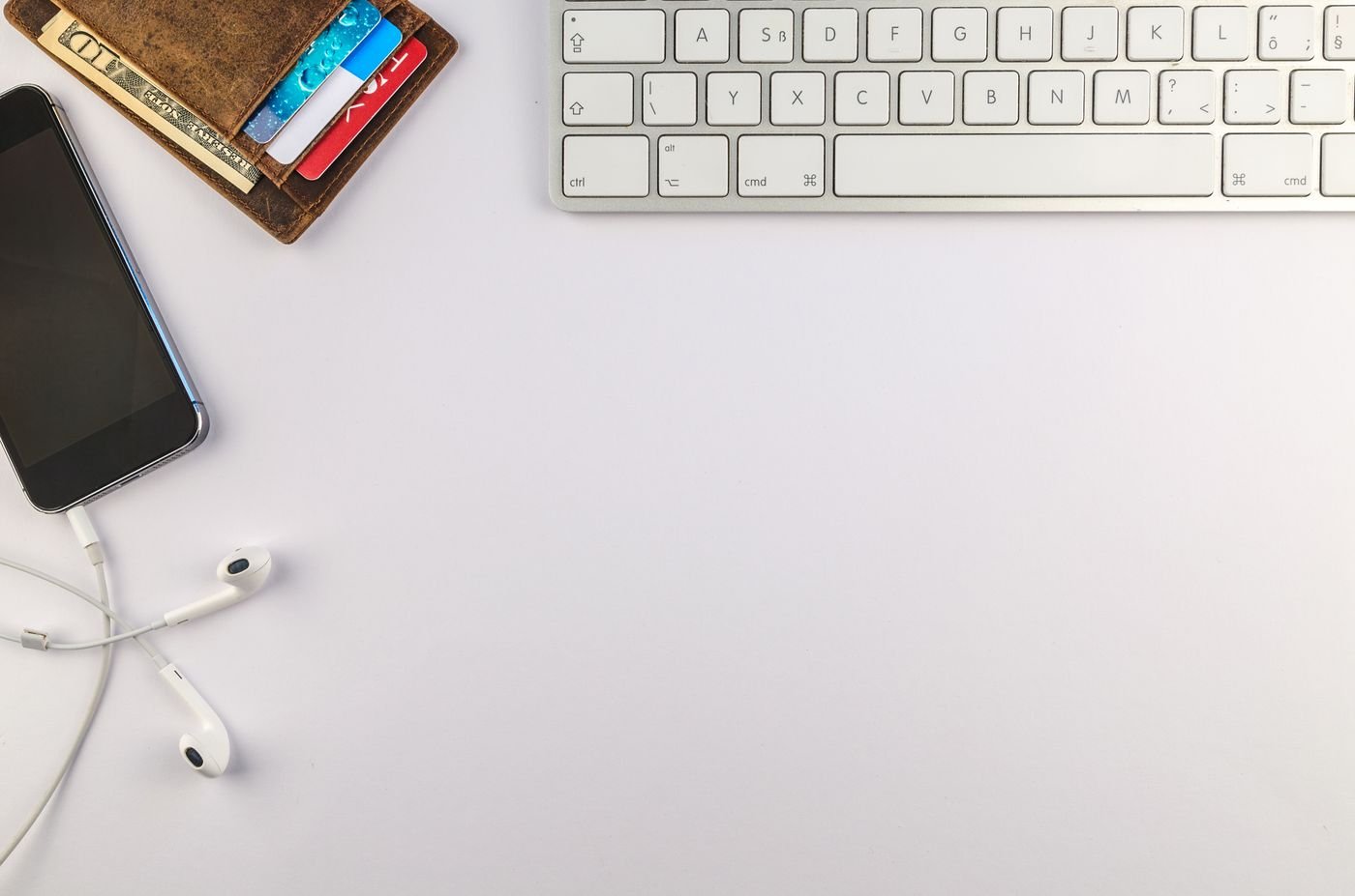 A phone and wallet beside a keyboard — illustrative photograph