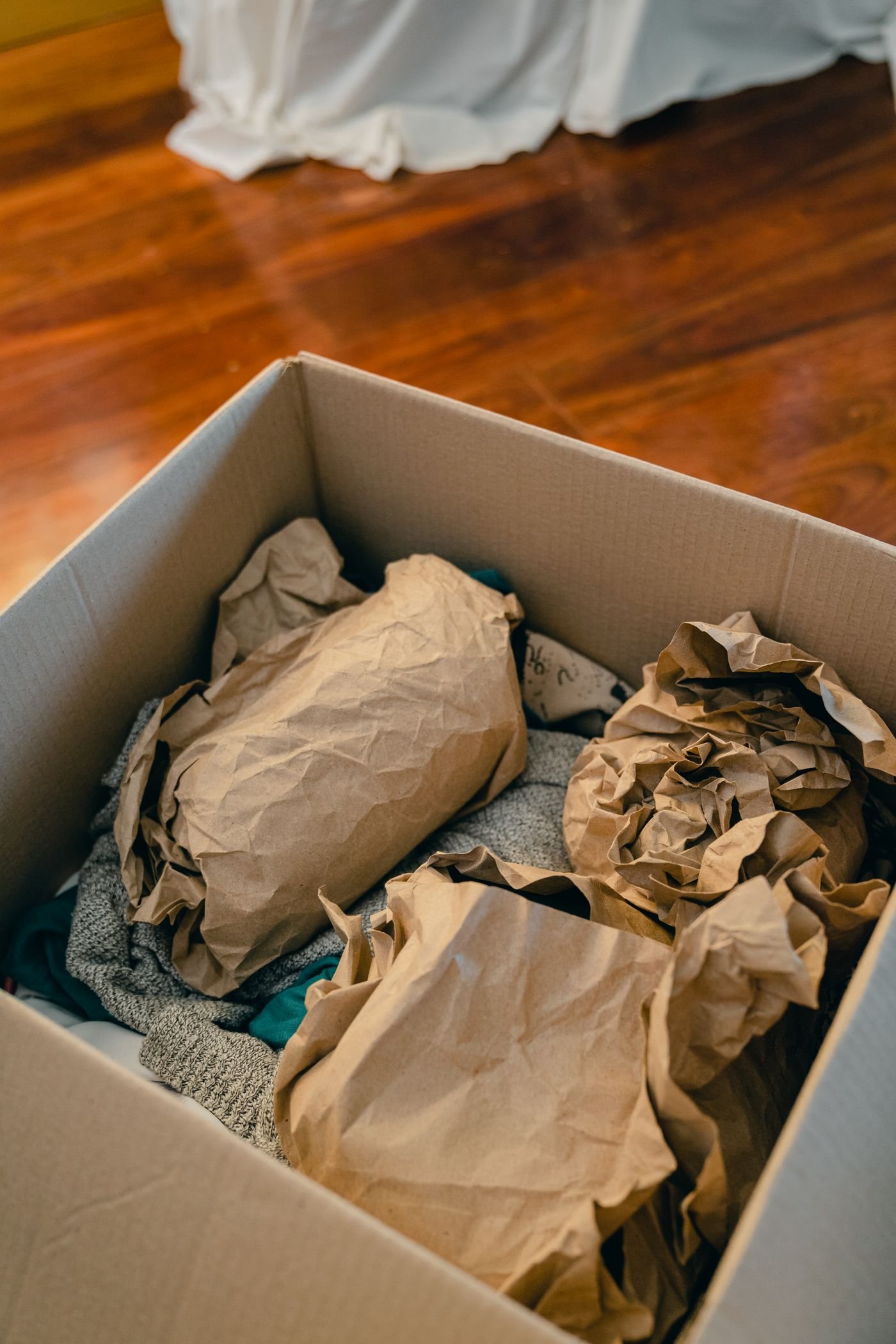 A cardboard box packed with paper-wrapped belongings