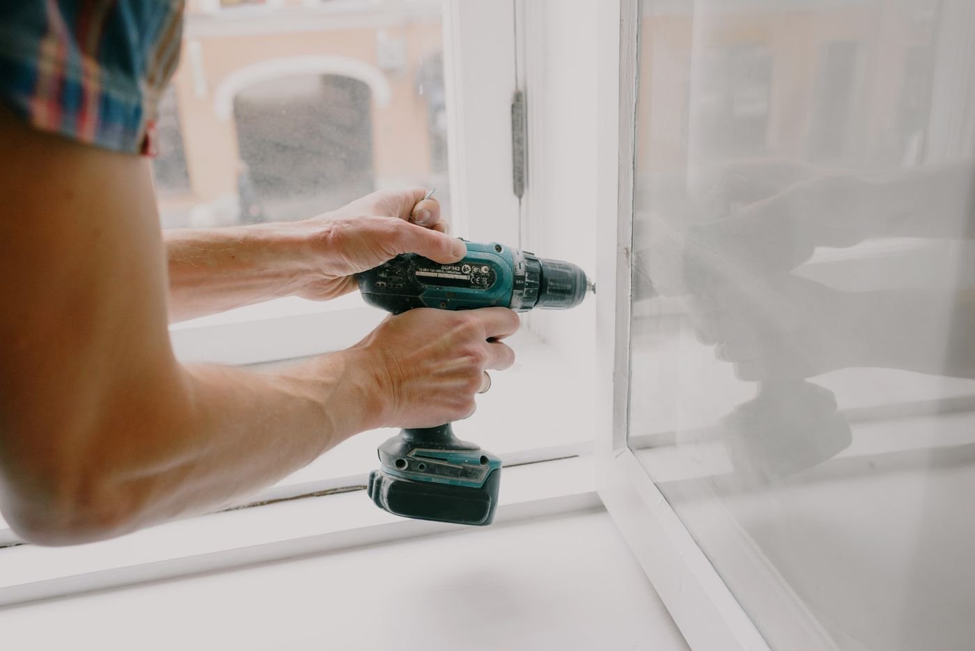 A worker repairing a window — illustrative photograph